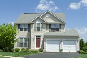 New Jersey custom home builder sample home, picture of exterior of New Jersey custom home with tan vinyl siding, green shutters, and red door