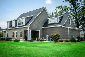 Evolution seed helps nourish and defend itself to produce lush green lawns like this one pictured in the backyard of a grey house. 