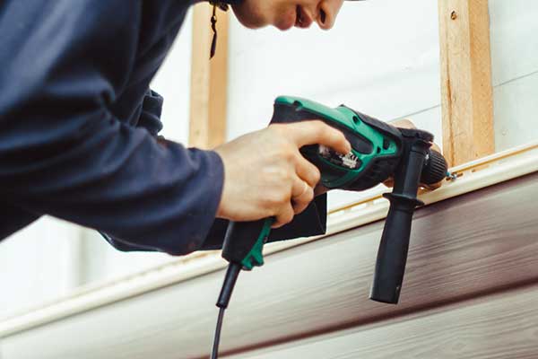 LBI siding contractor, Close-up of LBI siding contractor installing tan vinyl siding