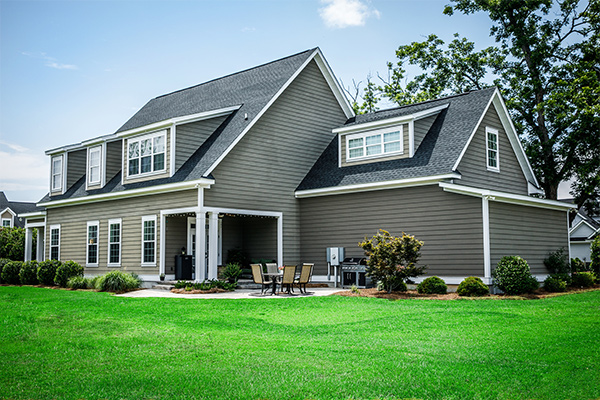 Greed sided home with lush green lawn because the homeowner did buy Evolution Seed